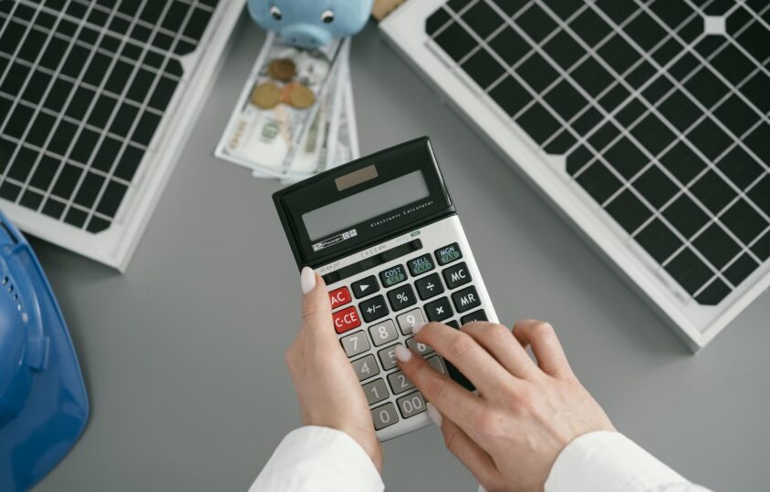 close up hand typing pocket calculator